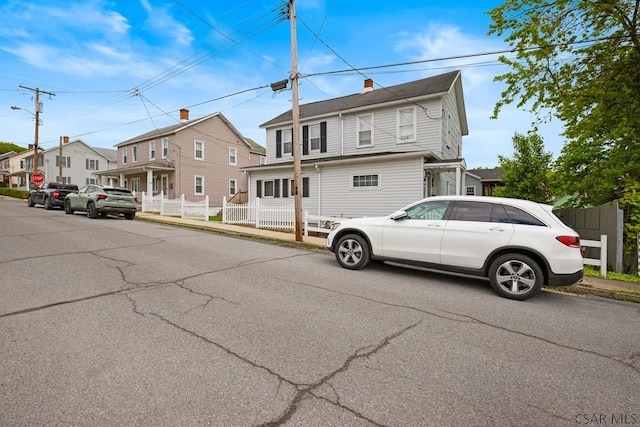 view of front of home featuring fence and a residential view