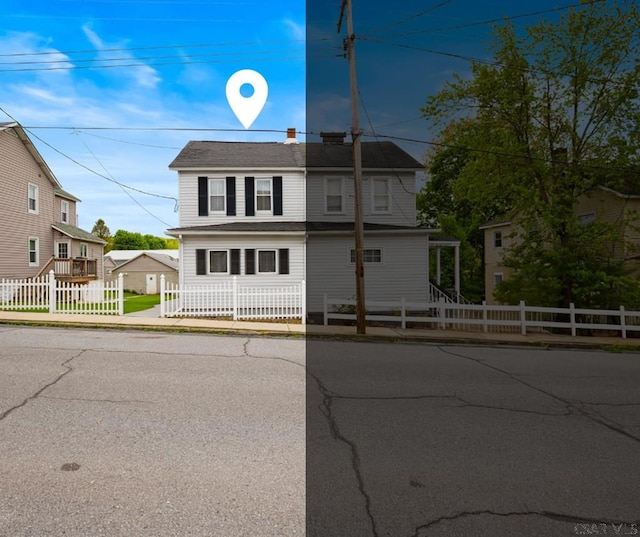 traditional home with a fenced front yard and a shingled roof