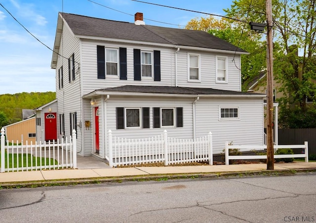 view of front of property with a chimney and a fenced front yard