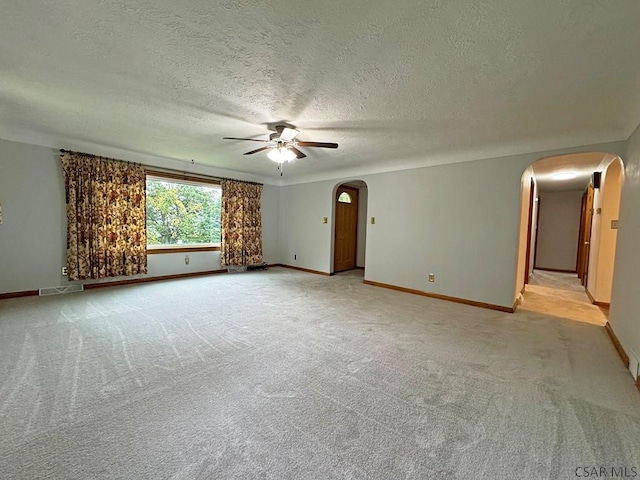 carpeted empty room with a textured ceiling and ceiling fan