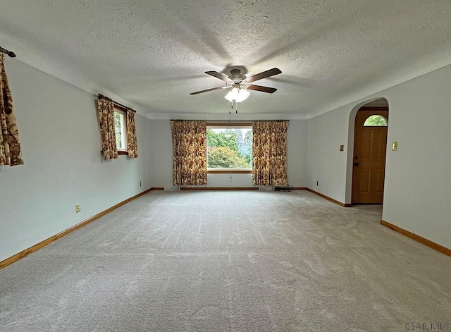 carpeted spare room featuring ceiling fan and a textured ceiling