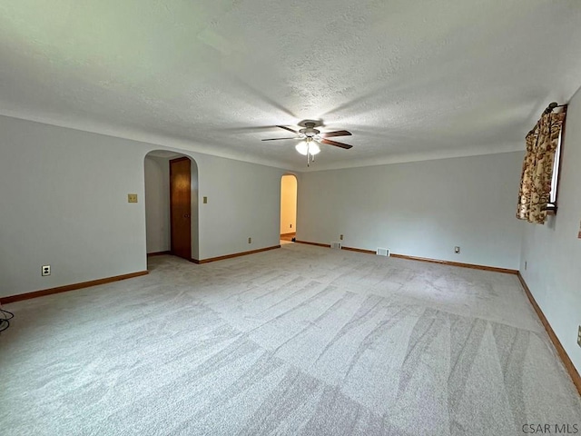 carpeted empty room with ceiling fan and a textured ceiling