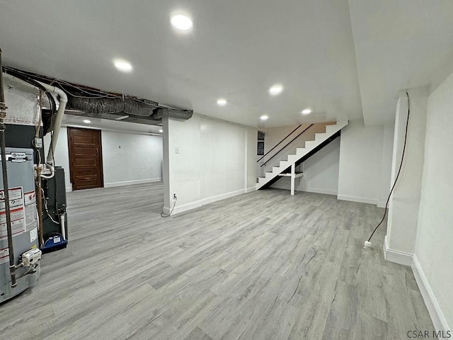 basement with light hardwood / wood-style flooring and gas water heater