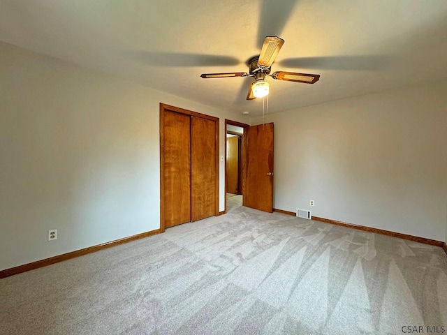 unfurnished bedroom with light colored carpet, ceiling fan, and a closet