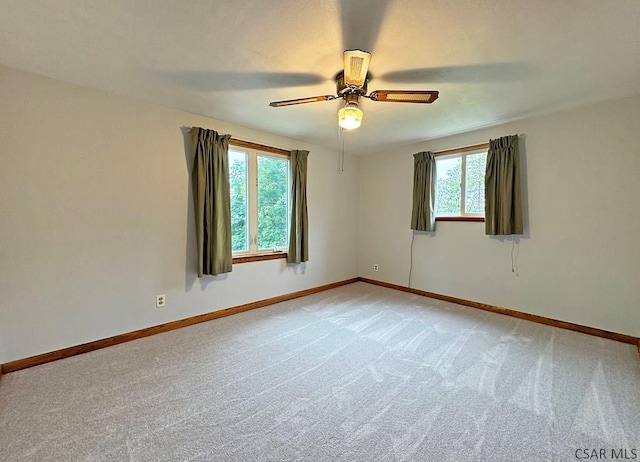 carpeted empty room with a wealth of natural light and ceiling fan