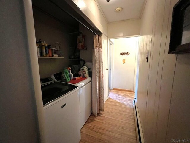 laundry area with a baseboard radiator, light wood-type flooring, separate washer and dryer, and laundry area