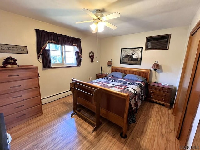 bedroom with wood finished floors, a ceiling fan, and baseboard heating