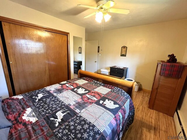 bedroom with baseboards, wood finished floors, ceiling fan, and a closet