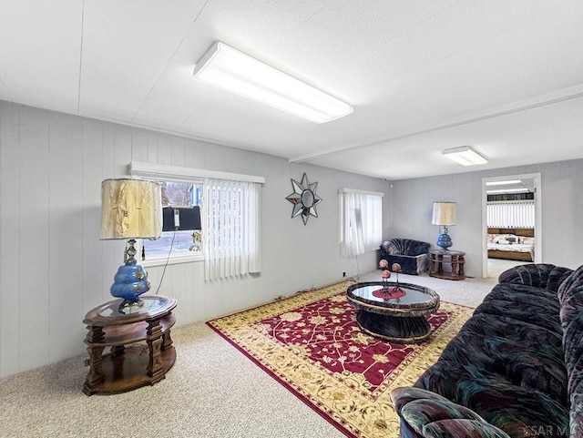 living room with plenty of natural light, wooden walls, and carpet floors