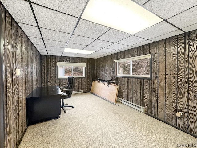 unfurnished office featuring light colored carpet, a drop ceiling, and baseboard heating