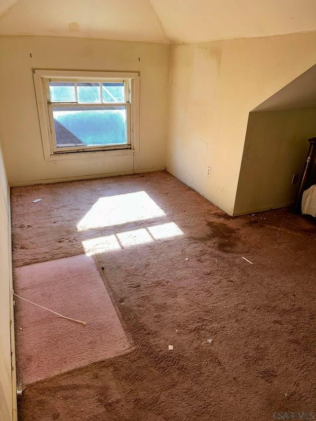 spare room with vaulted ceiling and carpet