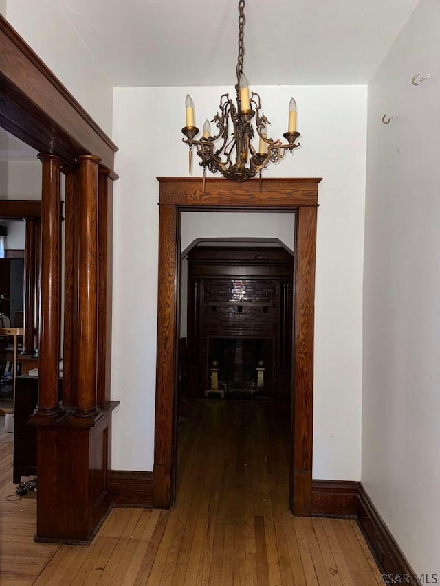 corridor featuring hardwood / wood-style flooring and a chandelier