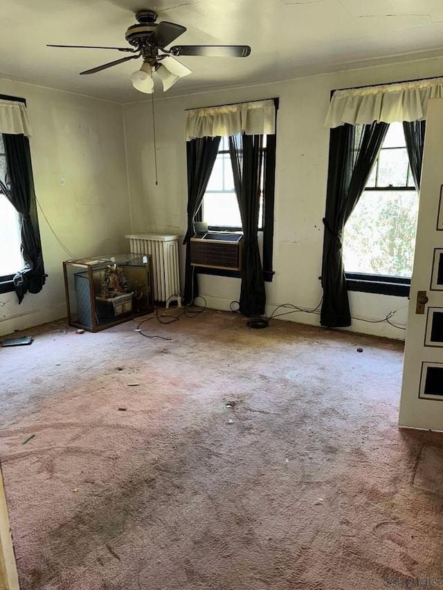 carpeted spare room with radiator and ceiling fan