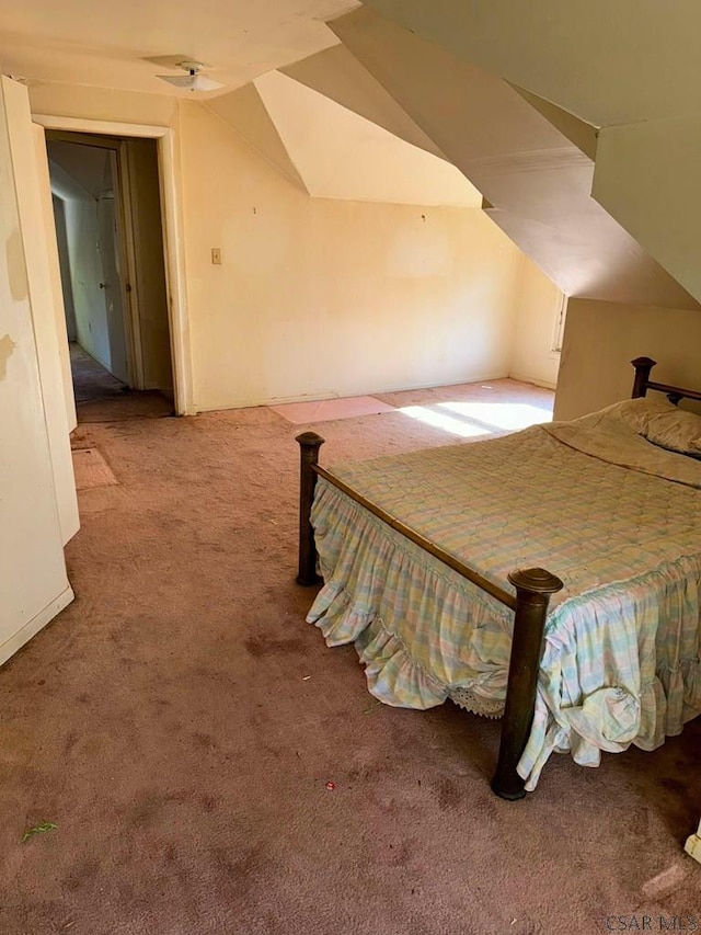 bedroom with carpet floors and vaulted ceiling