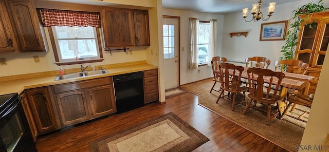 kitchen with dark hardwood / wood-style floors, sink, a chandelier, hanging light fixtures, and black appliances