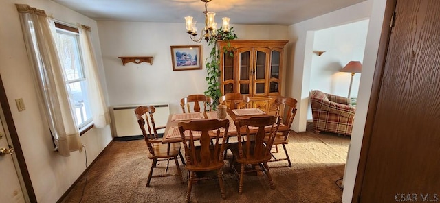 carpeted dining room featuring a chandelier