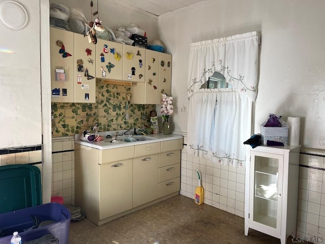 kitchen featuring tile walls, sink, and cream cabinetry