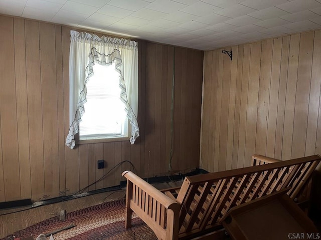 bedroom with wood-type flooring and wood walls