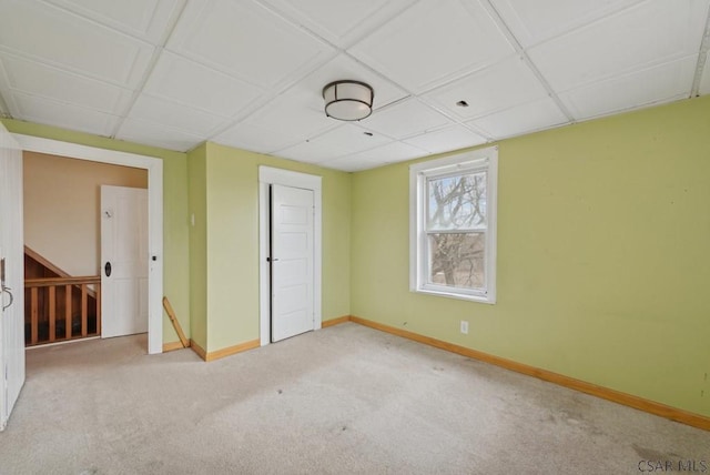 spare room with light carpet and a drop ceiling