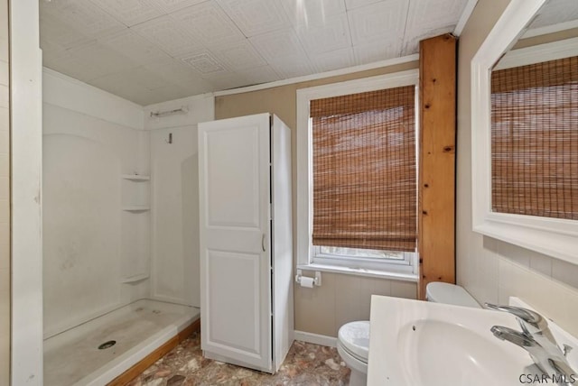 bathroom with sink, toilet, and a shower