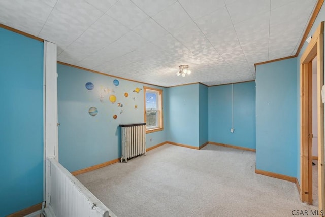 carpeted spare room featuring crown molding and radiator heating unit