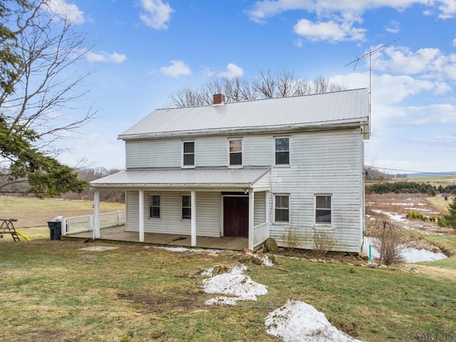 rear view of property featuring a patio area and a lawn