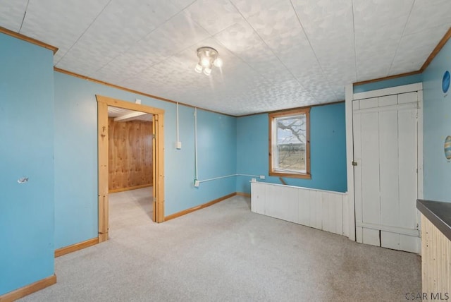 interior space with crown molding, carpet, and wood walls