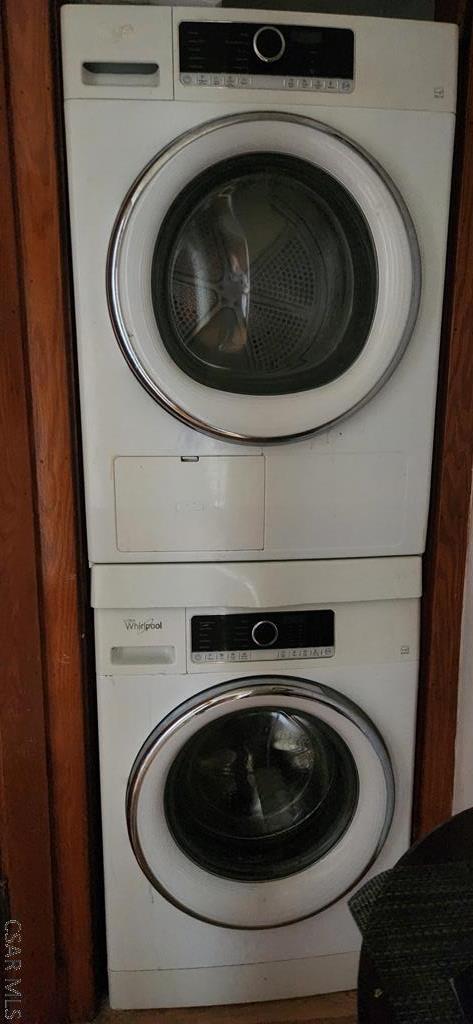 clothes washing area with stacked washer and dryer