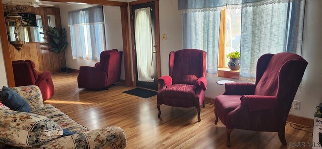 living area with a wealth of natural light, light hardwood / wood-style floors, and ceiling fan