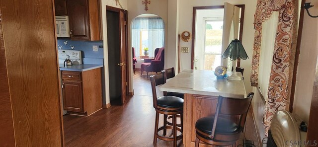 kitchen with dark hardwood / wood-style flooring, range, and a breakfast bar