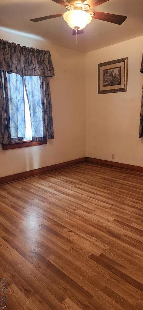 empty room with wood-type flooring and ceiling fan