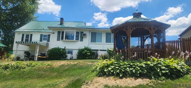 back of property with a gazebo and a lawn