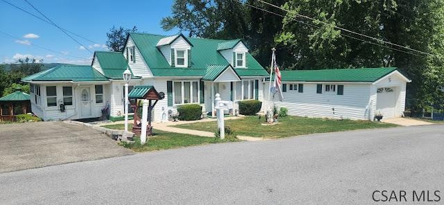 view of front of house with a garage and an outbuilding