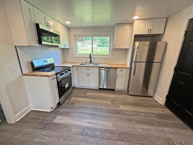 247 Jefferson Ave, Windber, PA 15963 - kitchen with appliances with stainless steel finishes, dark wood-type flooring, white cabinetry, backsplash, and recessed lighting