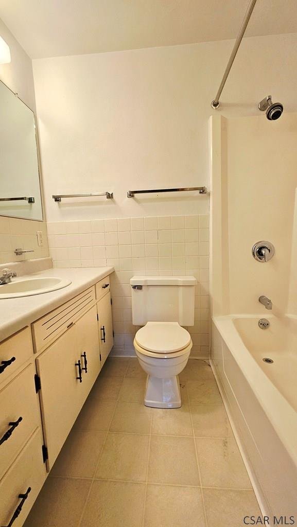2139 Woodcrest Dr, Johnstown, PA 15905 - full bath featuring vanity, tile walls, toilet, tile patterned flooring, and shower / tub combination