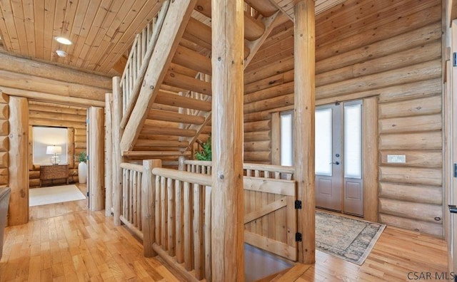 corridor with light wood-style floors and wood ceiling