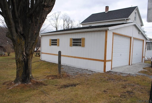 view of side of property with a garage and an outbuilding