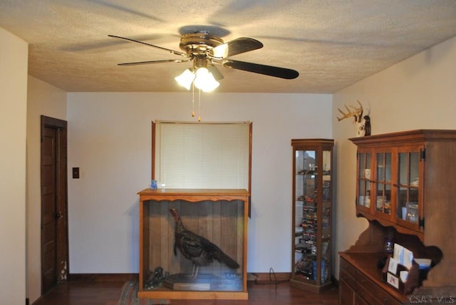 living room with ceiling fan, dark wood-type flooring, and a textured ceiling