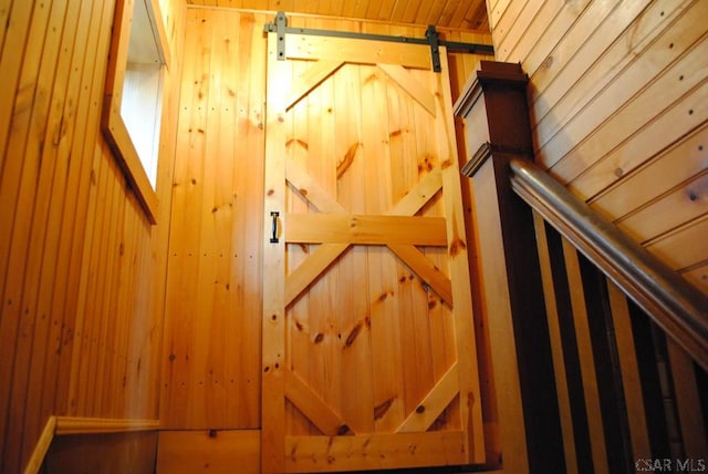 interior space featuring a barn door and wood walls