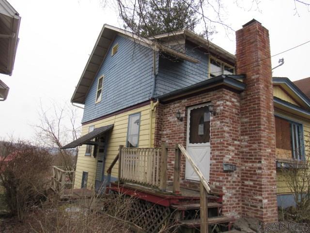 back of property with brick siding and a chimney