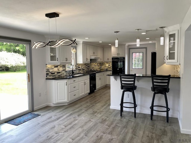 104 Erin Rd, Johnstown, PA 15905 - kitchen featuring black appliances, dark countertops, a peninsula, a kitchen bar, and a sink
