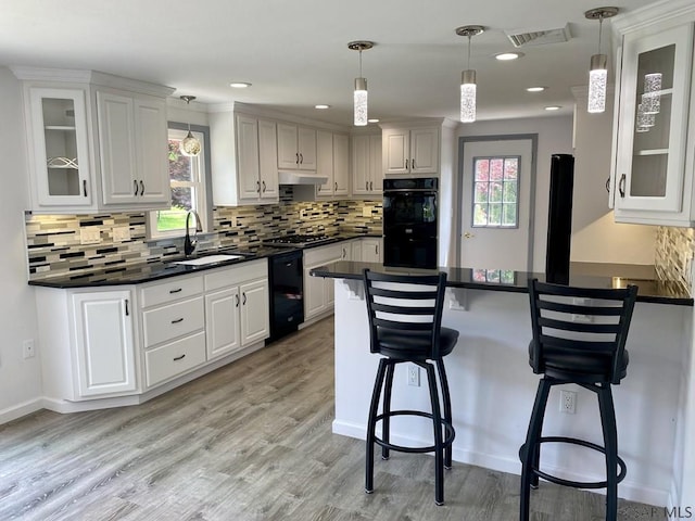 104 Erin Rd, Johnstown, PA 15905 - kitchen featuring a sink, a peninsula, black appliances, dark countertops, and a kitchen bar