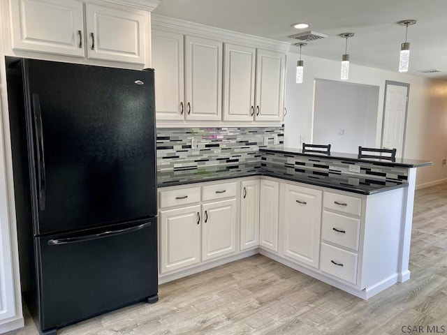 104 Erin Rd, Johnstown, PA 15905 - kitchen with freestanding refrigerator, a peninsula, dark countertops, light wood-type flooring, and white cabinetry