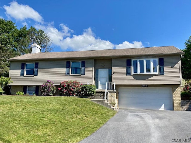 104 Erin Rd, Johnstown, PA 15905 - split foyer home featuring a garage, a chimney, asphalt driveway, a front lawn, and brick siding