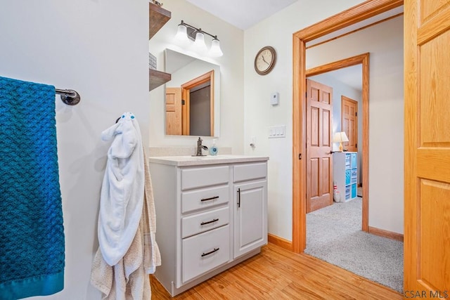 bathroom featuring vanity, baseboards, and wood finished floors