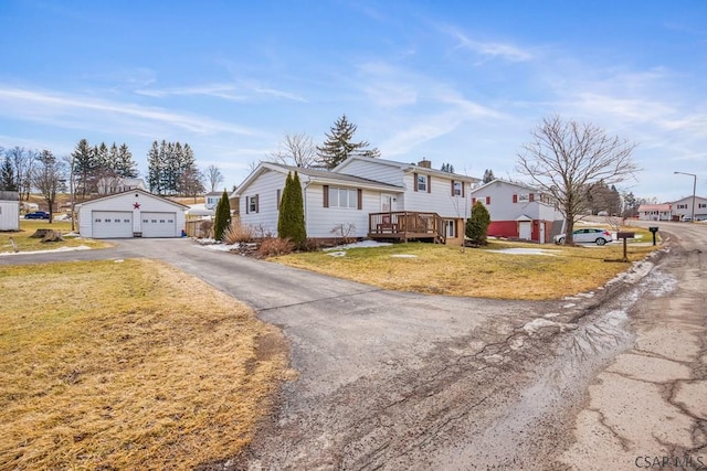 view of front of property featuring a garage, a residential view, an outbuilding, a deck, and a front lawn