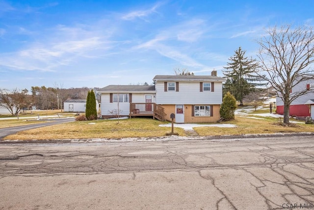 split level home with a chimney and a front lawn