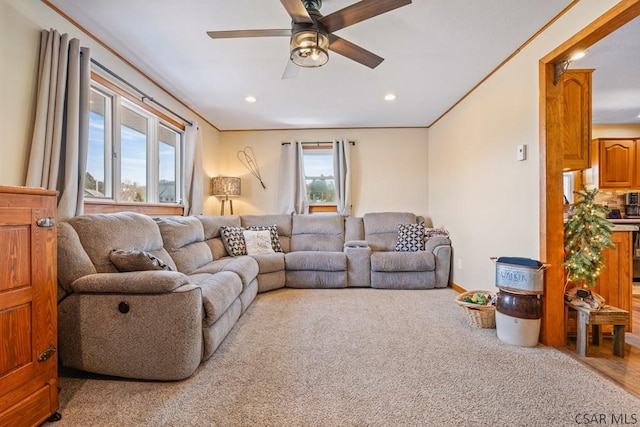 carpeted living area featuring baseboards, ornamental molding, a ceiling fan, and recessed lighting