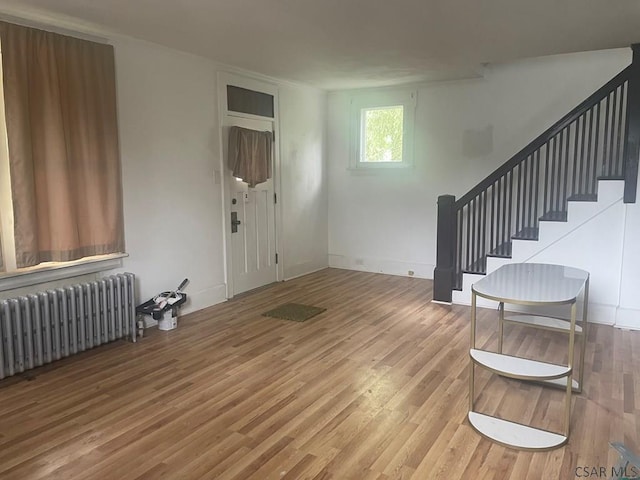 209 Dupont St, Johnstown, PA 15902 - foyer with radiator heating unit, stairway, and wood finished floors