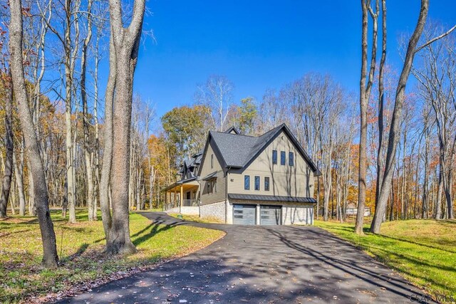 view of property exterior with a garage and a lawn